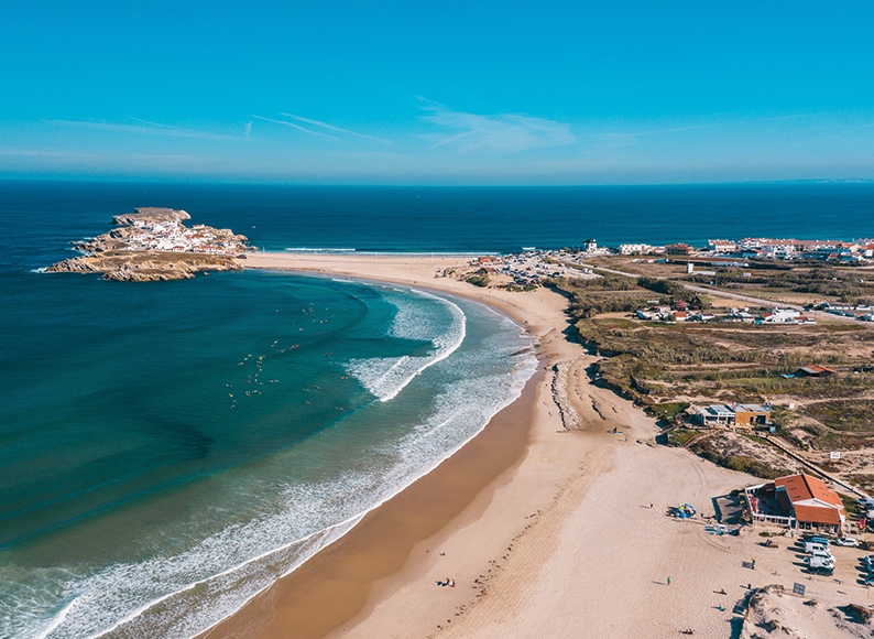 Aerial view of Baleal peninsula, sandy bay and surf lines