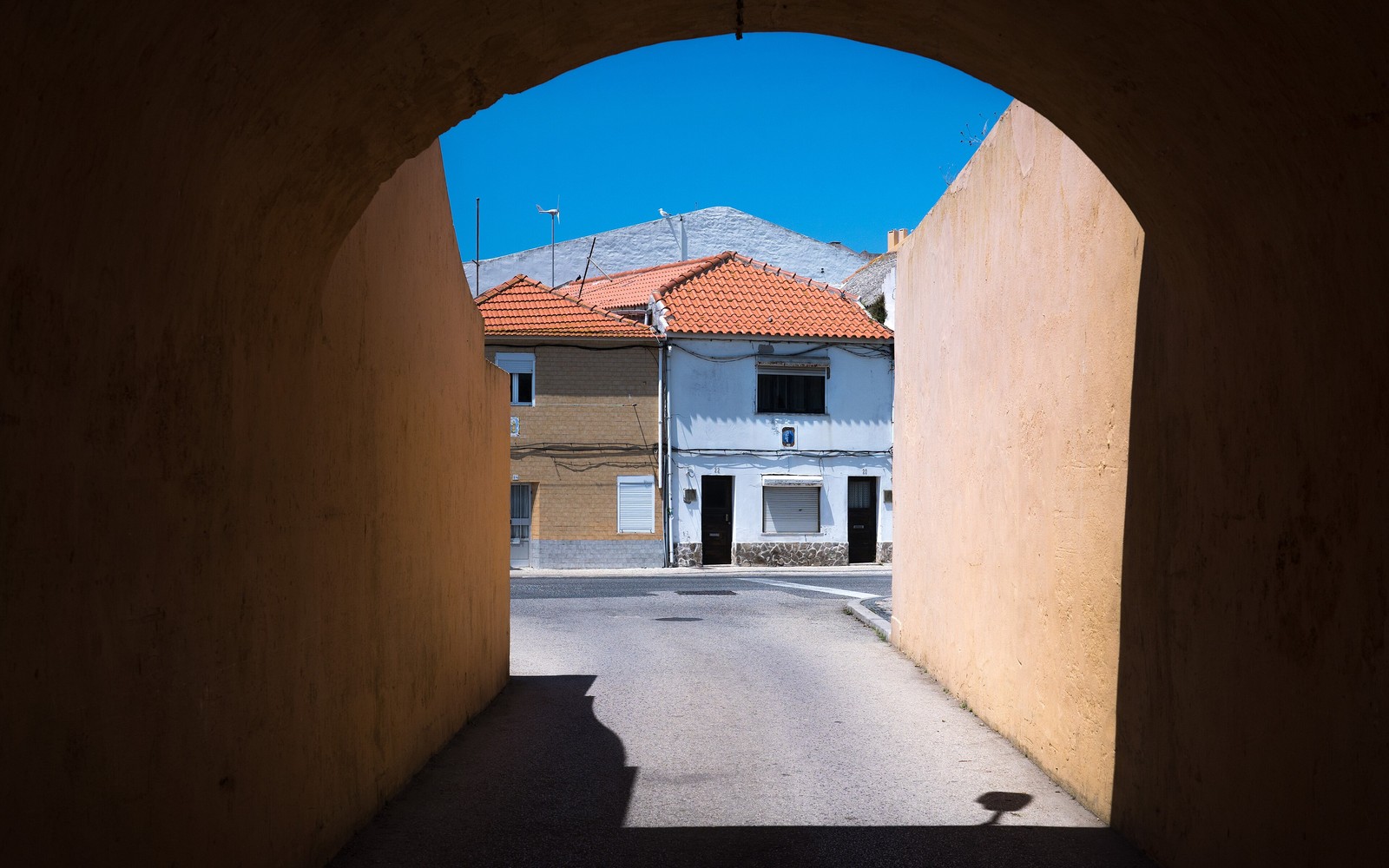Traditional Peniche street framed by a historic archway