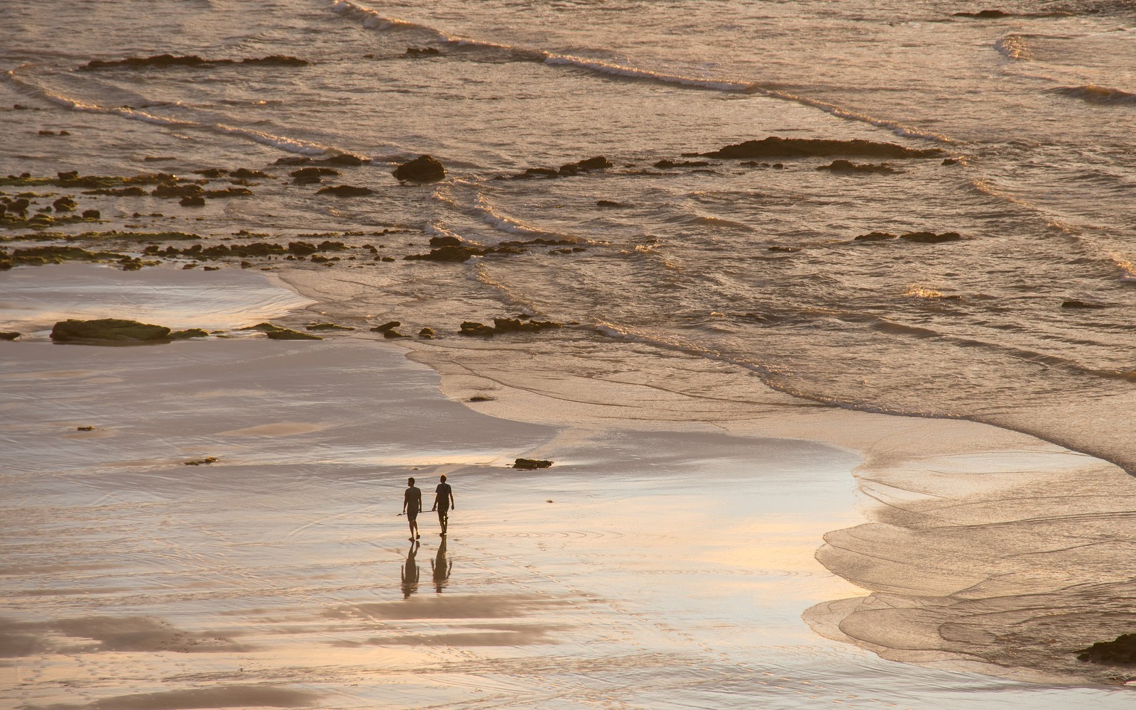People walking together on Baleal beach at low tide