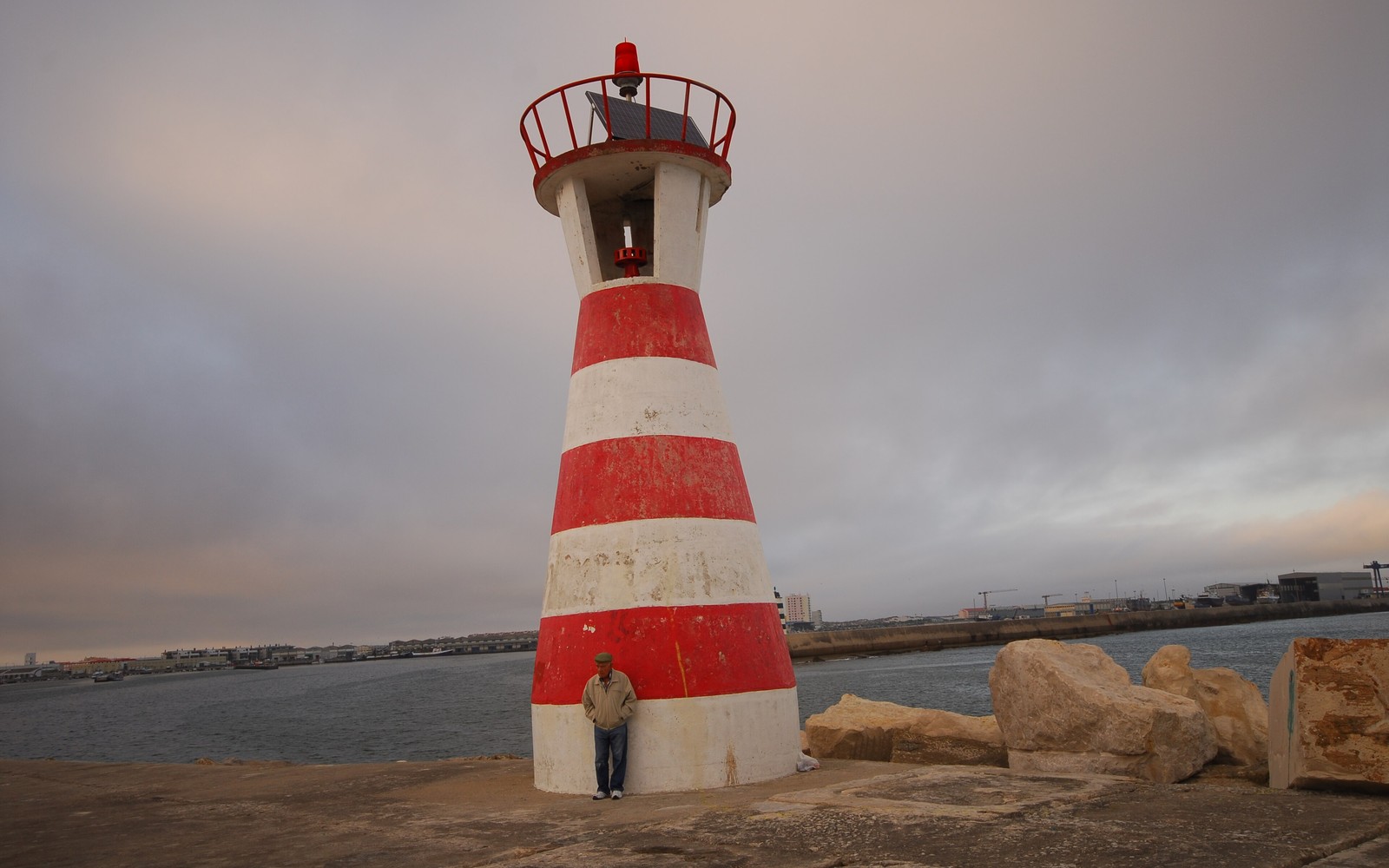 Red and white lighthouse on the harbour wall in Peniche