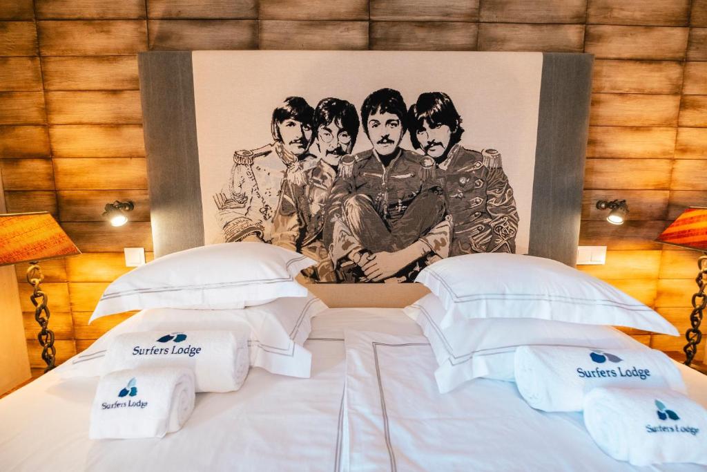 Branded bed and wood-lined wall at Surfers Lodge Peniche