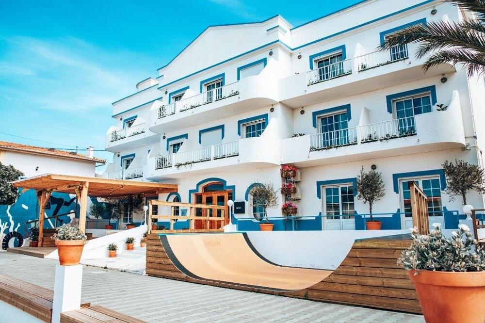 White and blue surf lodge with a courtyard in Ferrel